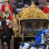 Kralja i kraljicu prate konji, muzičari i navijači koji mašu 14