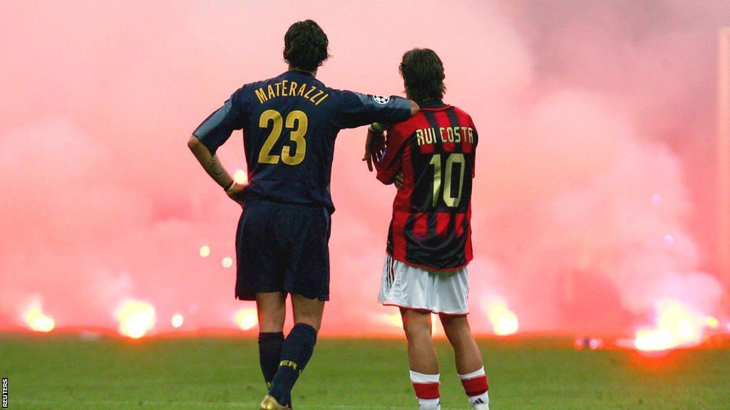 Inter, Milan i Liga šampiona: Fudbalski rat u Milanu i fotografija koja će ostati za večnost 2 Marco Materazzi leans on the shoulder of Rui Costa as the pair watch smoke rise from flares thrown from the stands during the 2005 Champions League quarter-final between AC Milan and Inter Milan
