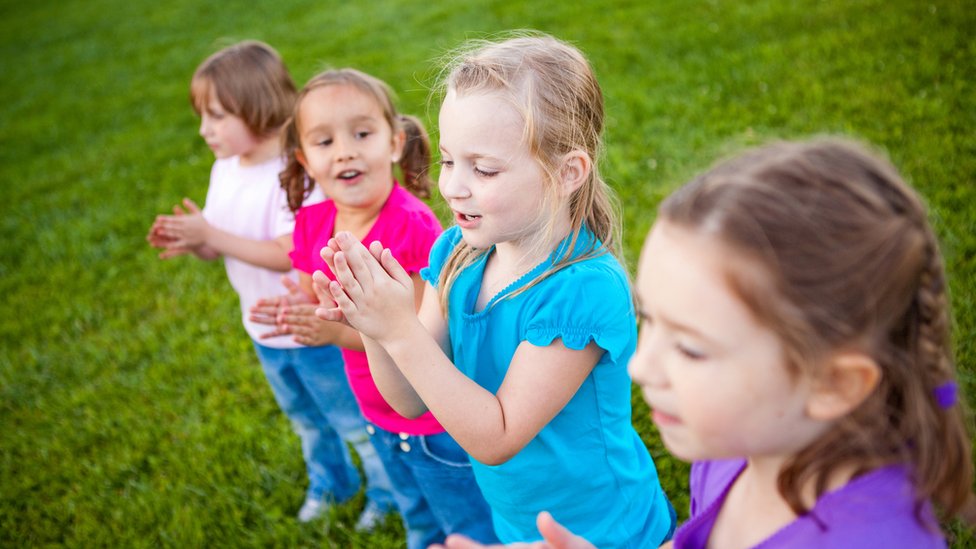 Predškolske ustanove: Mikrosvet druženja, učenja kroz igru i razvoja u obdaništima 2 Stock image of four little girls clapping