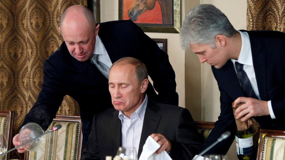 Rusija i Ukrajina: Korišćenje tinejdžera za širenje Putinove propagande u Ukrajini 4 Yevgeny Prigozhin helping Vladimir Putin at a dinner table, 2011