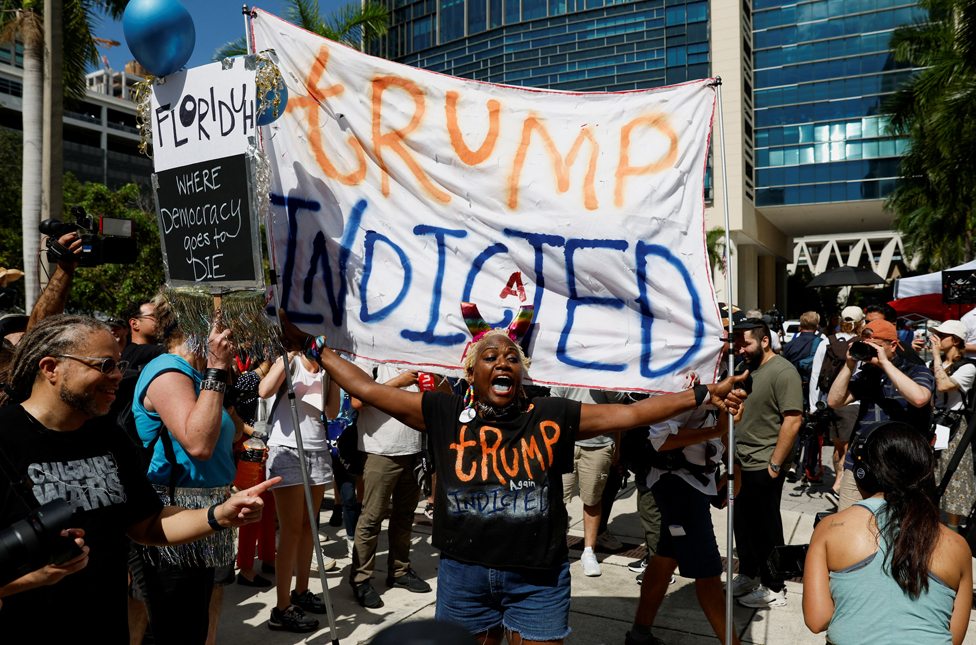 Amerika: Donald Tramp na sudu u Majamiju po optužbi za zadržavanje poverljivih dokumenata - galerija 13 A person holds a banner near The Wilkie D. Ferguson Jr. United States Courthouse, on the morning former U.S. President Trump is to appear there on classified document charges, in Miami, Florida, U.S., June 13, 2023
