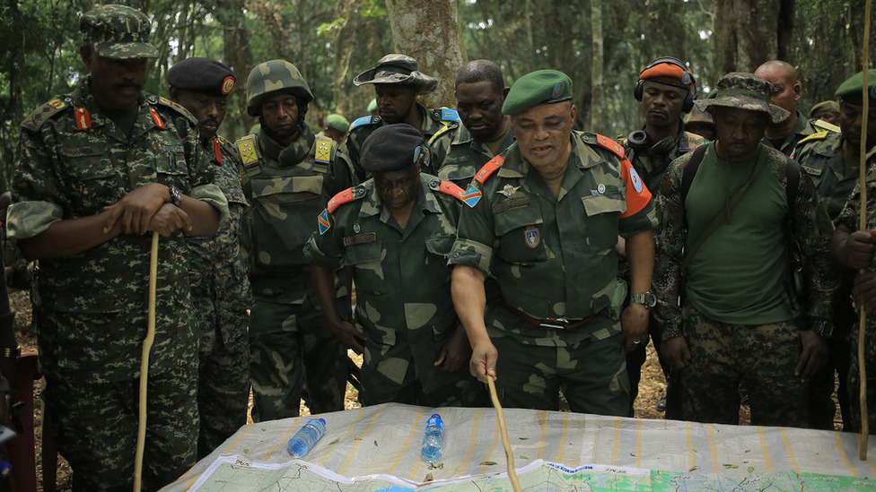 Napad na školu u Ugandi: „Razmazao sam krv po sebi da bih se sakrio“ 2 Major General Camille Bombele, coordinator of the Joint Armed Forces of the Democratic Republic of Congo-Ugandan People's Defence Forces Military Operations talking with officers at the headquarters in the Virunga National Park on 17 December 2021
