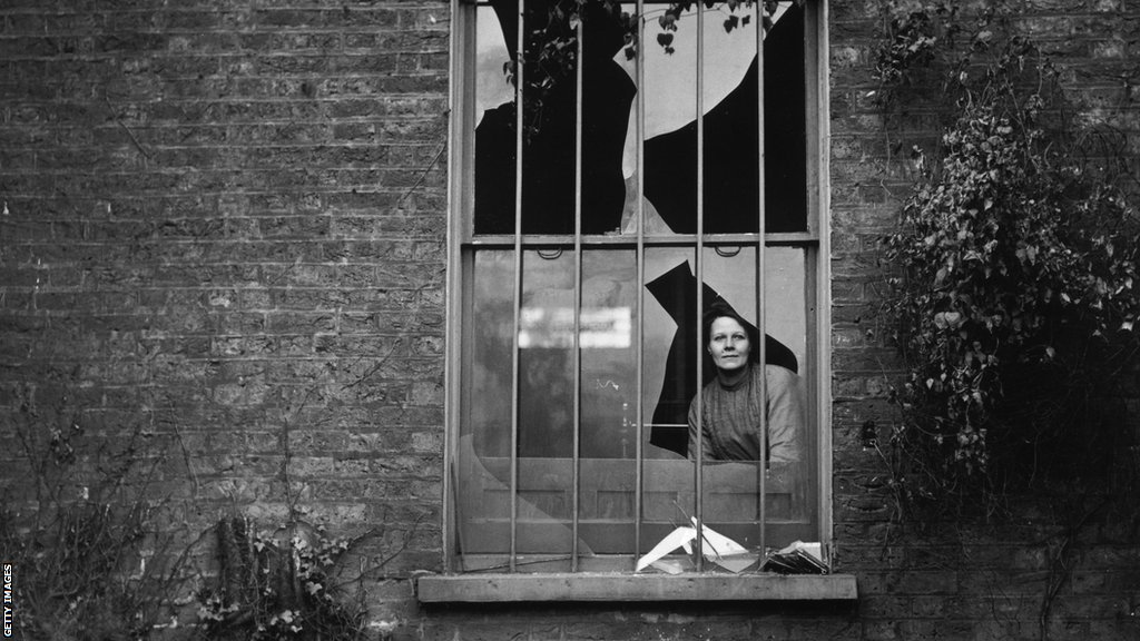 Žena viri kroz razbijen prozor u zatvoru Holovej posle bombaškog napada u decembru 1913. Sumnja se da iza napada stoji Ženska društveno-politička unija