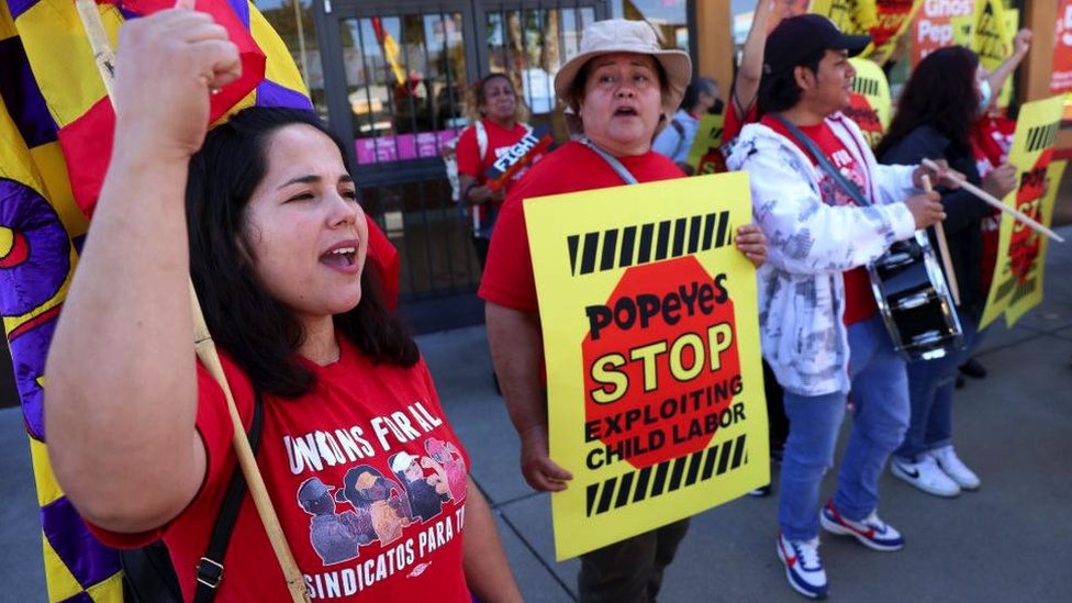 Protesters chant against child labour outside a fast food restaurant