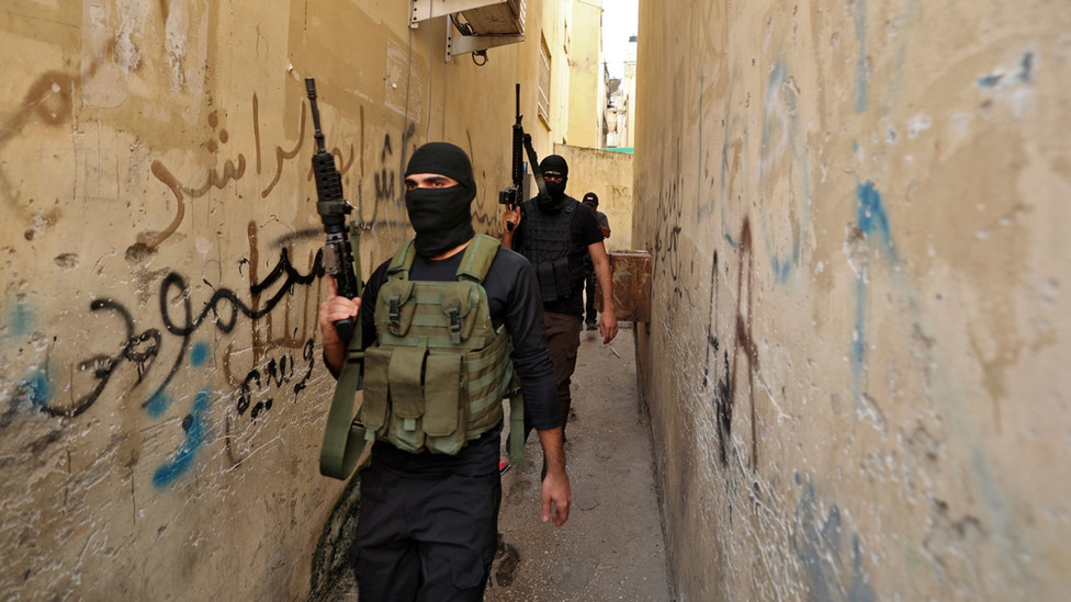 Members of the Saraya al-Quds, affiliated with the Palestinian Islamic Jihad Movement, walking through alleyways, October 14, 2022.