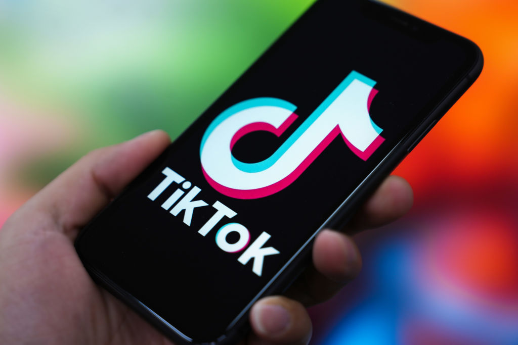 the TikTok logo is displayed on the screen of a smartphone