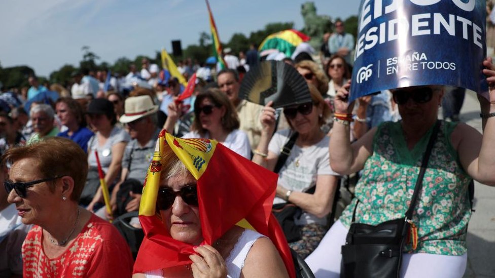 Španija i politika: Konzervativcima najviše glasova, ali niko nema većinu da napravi vladu 5 Supporters of People's Party (PP) shelter from the heat during a rally with opposition leader Alberto Nunez Feijoo at Retiro park ahead of elections in Madrid, Spain, June 18, 2023.