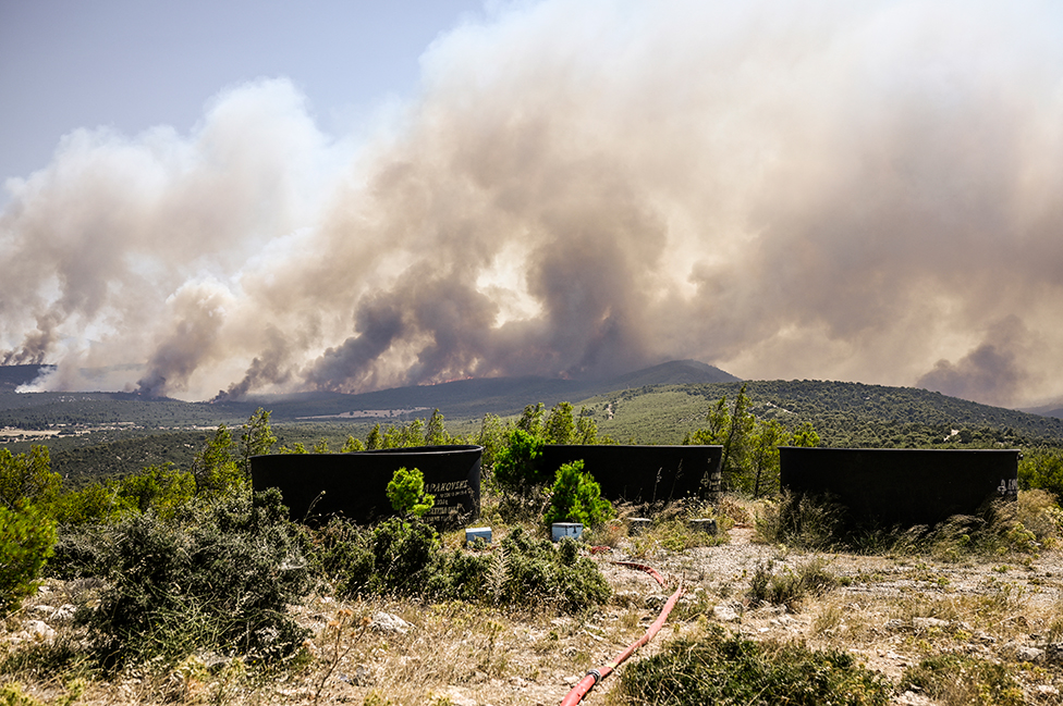 Water tanks for firefighting helicopters are pictured after wildfires broke out in the area of Magoula, southwest of Athens, Greece