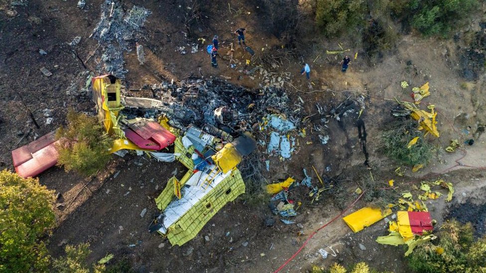 Rescuers operate at the site where a firefighting plane crashed after a water drop as a wildfire burns in Platanistos on the island of Evia, Greece, July 25, 2023.