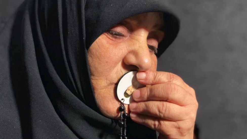 Yusra Al Amin kissing a pendant