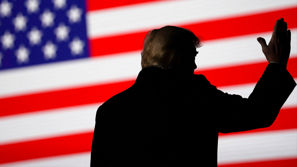 Amerika i Donald Tramp: Da li bi bivši predsednik mogao da završi u zatvoru i druga ključna pitanja 1 Donald Trump silhouetted against a US flag