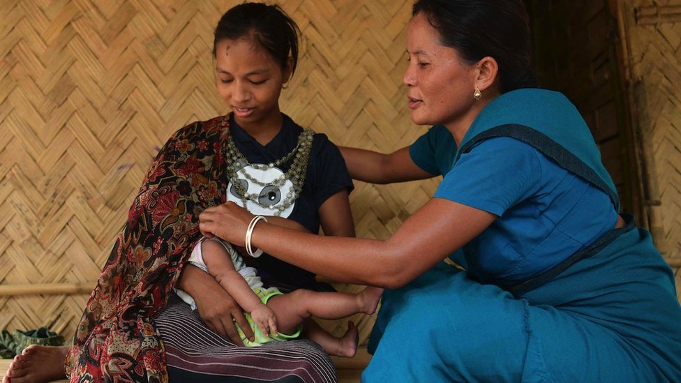 An accredited health worker explains the benefit of breastfeeding a baby to a mother from the Reang Tribe at her bamboo hut in Birendranagar Village, Jolaibari, Agartala, India.