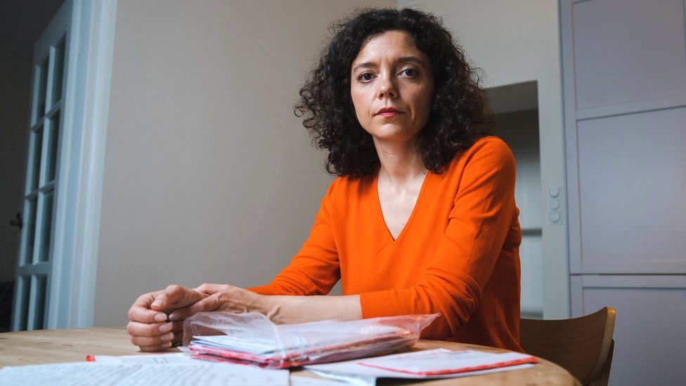 Belorusija: Politički zatvorenici potpuno izolovani, hoće da im slome duh 2 Tatsiana Khomich sits at a desk covered in files and documents