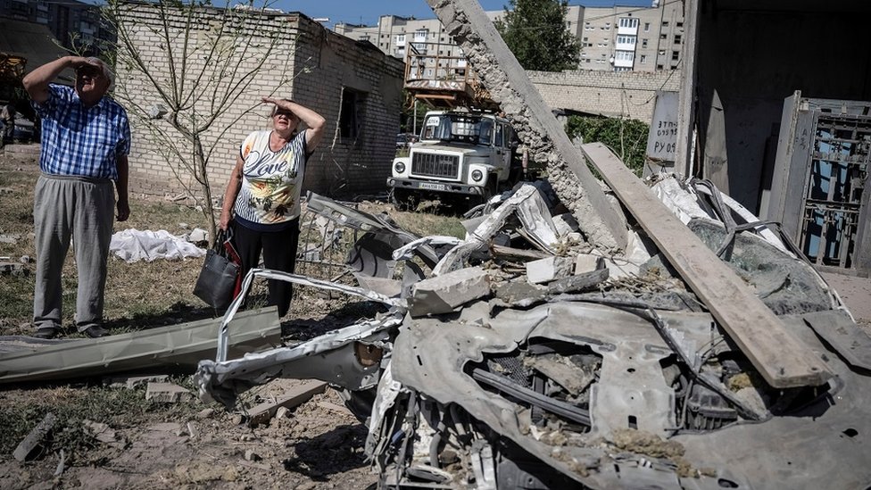 Local residents stand outside an apartment building damaged by a Russian missile strike, amid Russia's attack on Ukraine, in Pokrovsk, Donetsk region, Ukraine August 8, 2023.