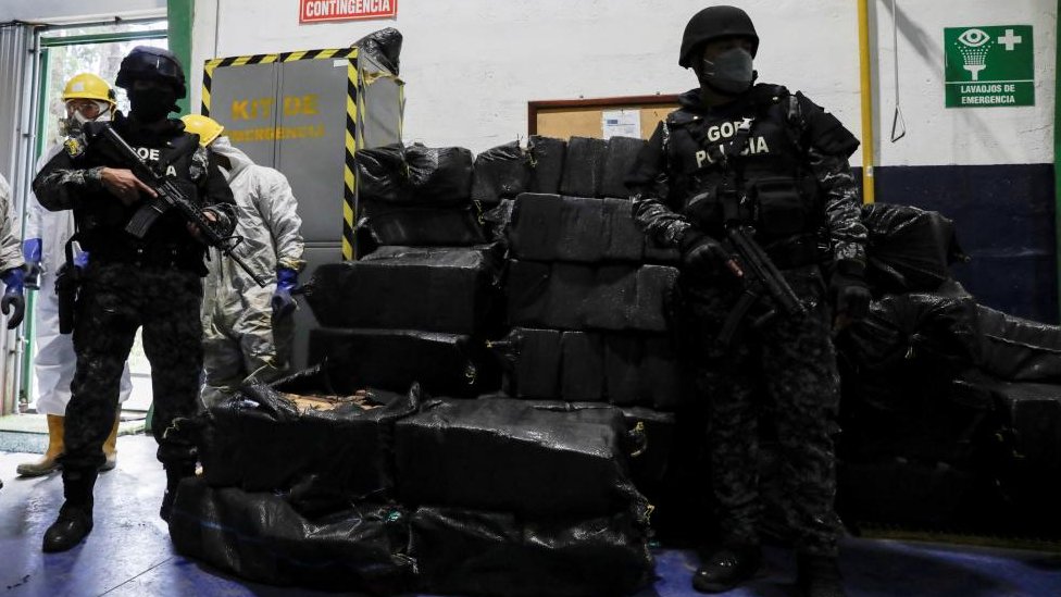 Politika i Latinska Amerika: Atentat u Ekvadoru - kako su zatvorske bande zavele strahovladu 2 Police officers keep watch next to sacks containing cocaine packages before the incineration of more than nine tons of cocaine seized during different operations, according to the Ecuador's Interior Ministry, in a warehouse at an undisclosed location, in Ecuador April 21, 2022.