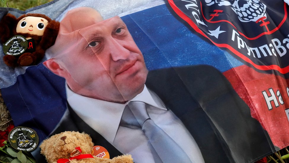 Rusija i Ukrajina: Deset tela izvučeno sa mesta nesreće aviona na čijem spisku putnika je bio šef Vagnera Prigožin 1 Zastava sa likom Prigožina ispred sedišta Vagnera u Sankt Peterburgu, gde ljudi odaju počast