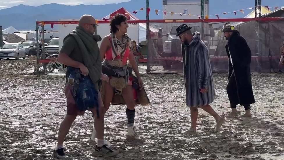 Burning Man: Tokom nevremena jedna osoba stradala, hiljade posetilaca zaglavljeno u blatu na poznatom festivalu u Americi 1 People walk through the mud at Burning Man in Nevada