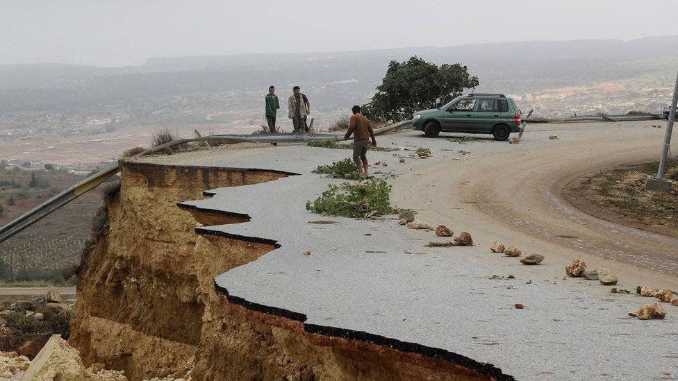Ljudi stoje na oštećenom putu pošto je snažna oluja pogodila grad Sahat, Libija, 11. septembar 2023.