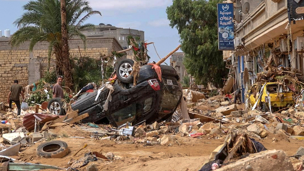 Poplave u Libiji: Strahuje se da će broj poginulih biti do 20.000 - „Voda je nosila ljude, bilo je kao sudnji dan" 8 A man stands next to a damaged car, after a powerful storm and heavy rainfall hit Libya, in Derna, Libya, on 12 September 2023