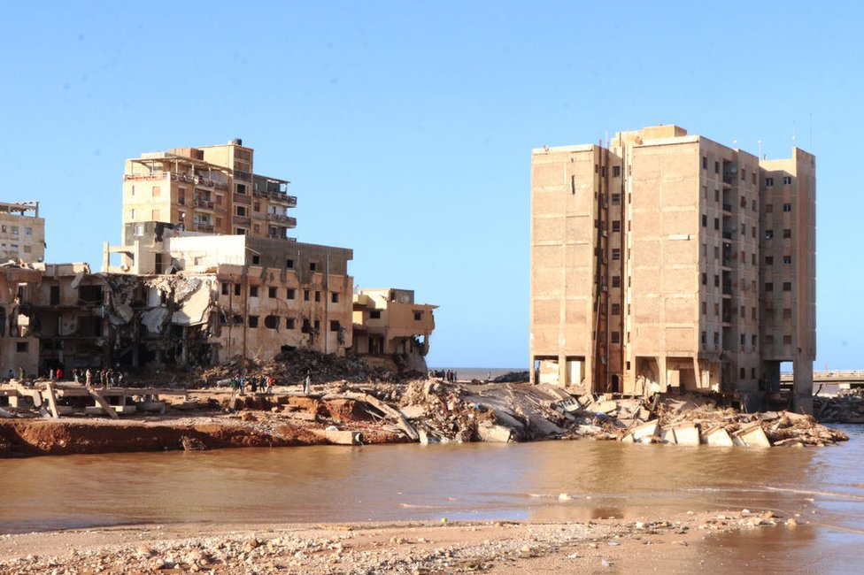The remains of Amna's building, right, after it partially collapsed in the flood.