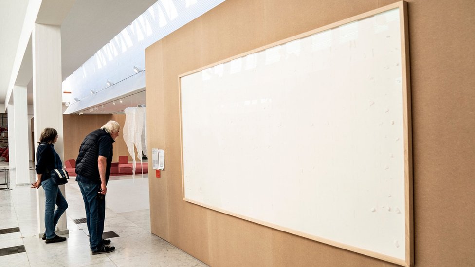 Dvoje ljudi gleda u prazna platna