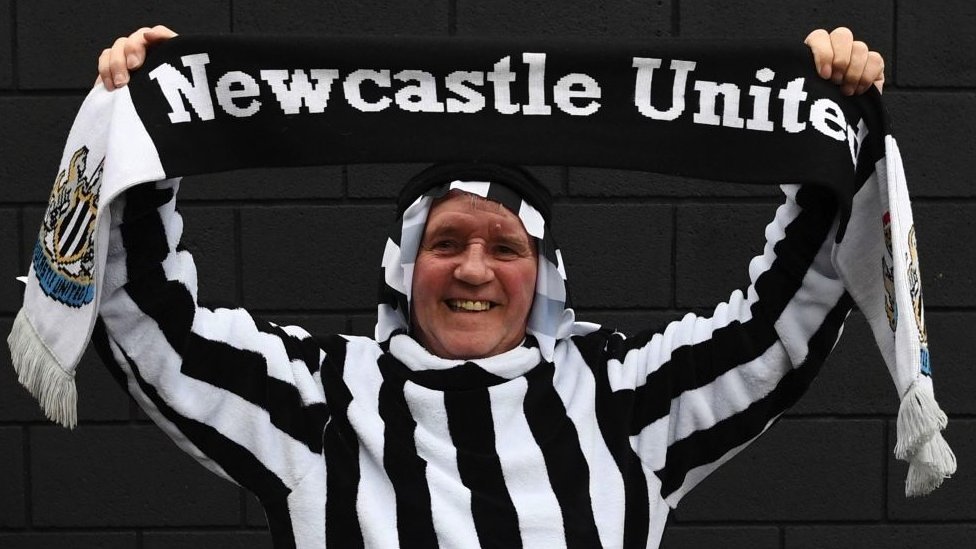 A Newcastle United supporter attends a game wearing an Arab costume in the club colours