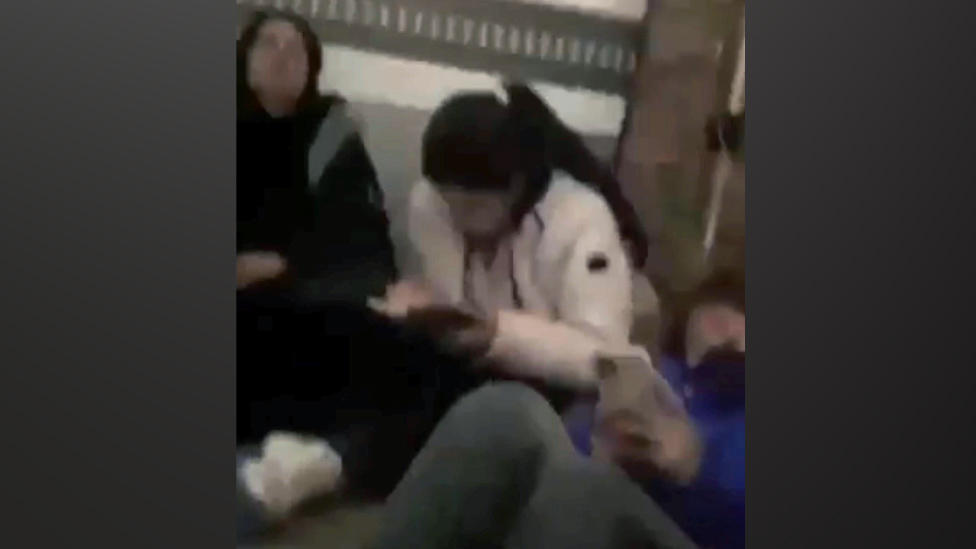 Trgovina ljudima: Kako je poziv BBC-ju spasio šest žena zarobljenih u hladnjači u Francuskoj 1 Video clip still showing the women sitting in the cramped space of a truck filled with banana crates.