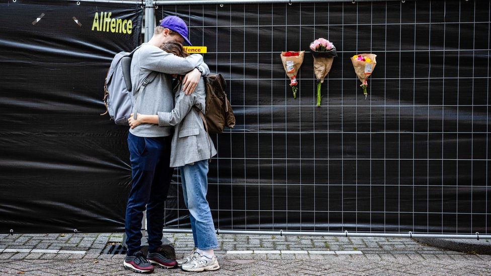 Pucnjava u Roterdamu: Ubijeno troje ljudi, napadač uhapšen - bolnica prethodno upozorena na njegovo „psihičko stanje“ 1 A man and woman hug next to flowers left at the building where a woman and her daughter were killed in Rotterdam