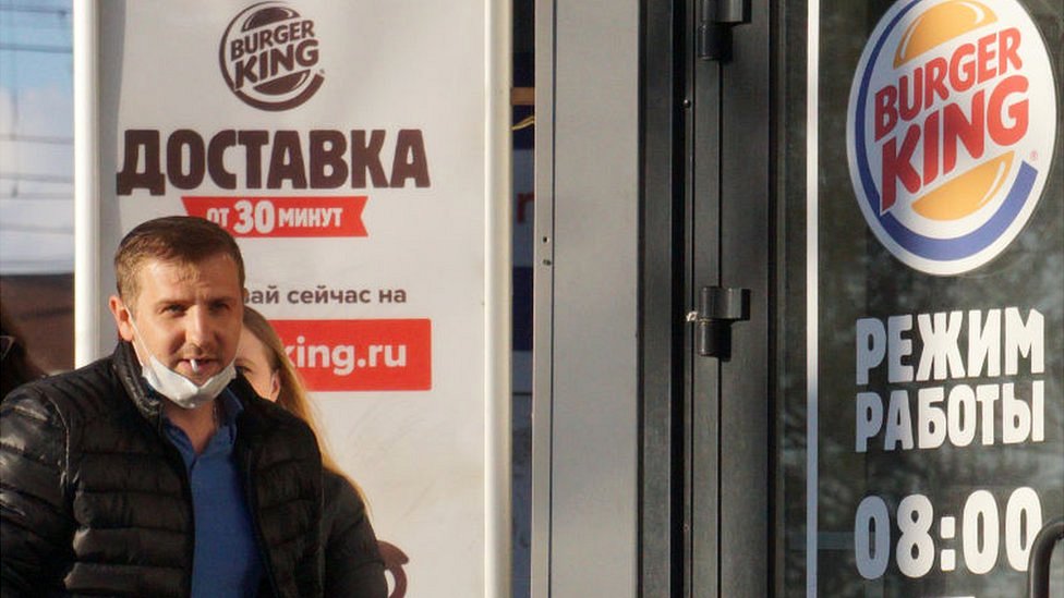 A man outside a Burger King restaurant in Russia.