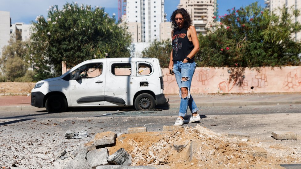 Izrael i Palestinci: Napad Hamasa šokirao Izraelce, ali šta je sledeće 1 A woman looks at a remnant of a rocket launched from Gaza that is lying on the ground, in Ashkelon, Israel