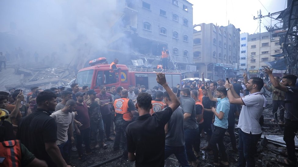 People in Gaza crowd around emergency workers following an air strike