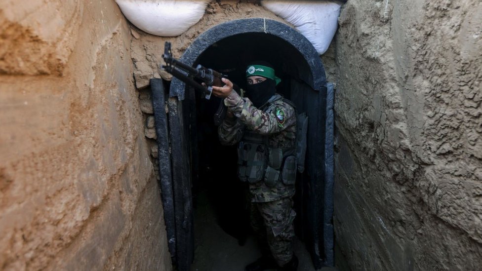 Fighter belonging to Hamas’ military wing stands in front of tunnel in central Gaza strip on 19 July 2023