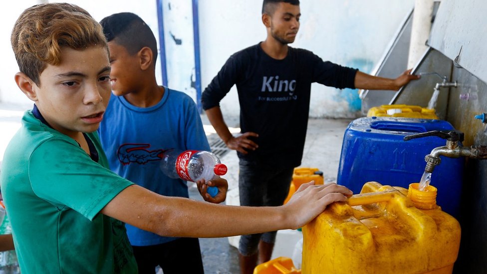 Children fill containers of water at public taps in Khan Younis, in the Gaza Strip (11 October 2023)