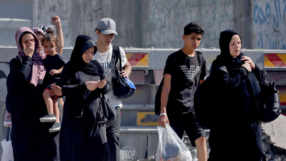 Palestinians with their belongings flee to safer areas in Gaza City after Israeli air strikes, on 13 October 2023