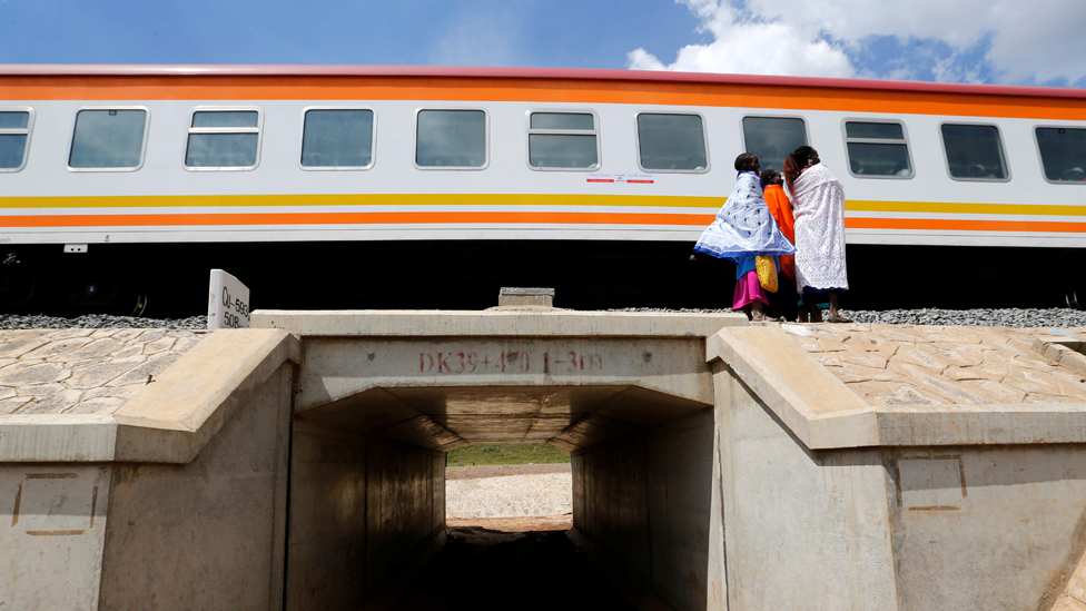 Kina: Kako je inicijativa Pojas i put vredna više biliona dolara promenila svet 4 Women stand next to a train on the Standard Gauge Railway line in Kimuka, Kenya in 2019