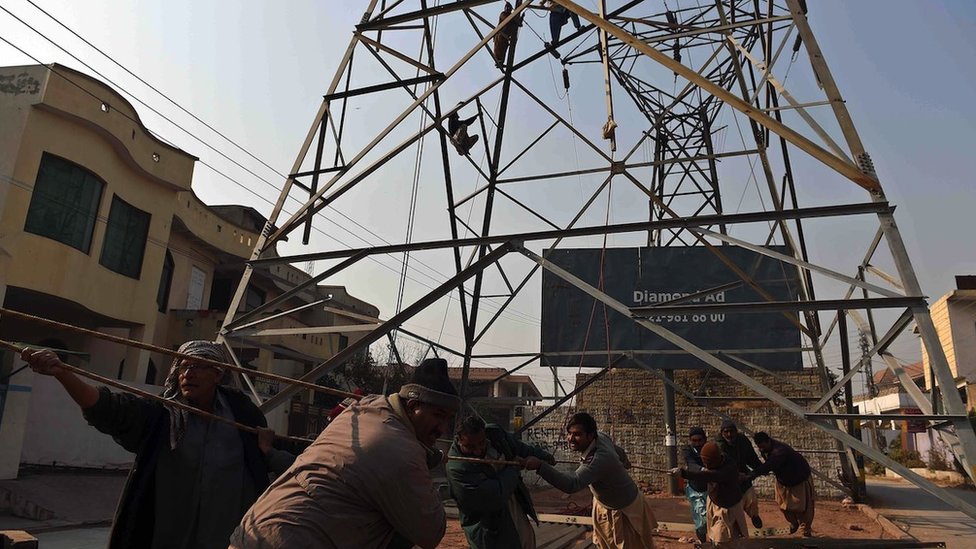 Kina: Kako je inicijativa Pojas i put vredna više biliona dolara promenila svet 10 Pakistani electricity workers pull a rope as they complete a high voltage power pole in Rawalpindi on 29 December 2014