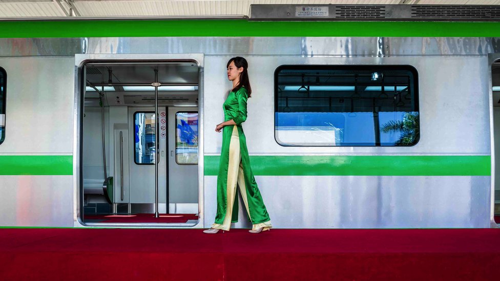 Kina: Kako je inicijativa Pojas i put vredna više biliona dolara promenila svet 11 Luu Hoai Thu, a receptionist for Vietnam's Cat Linh-Ha Dong Project Management Board, walks by a model carriage on display for public consultation on 17 November 2015