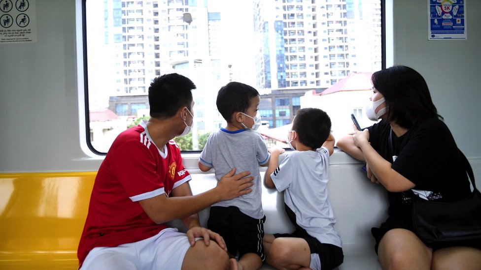 Kina: Kako je inicijativa Pojas i put vredna više biliona dolara promenila svet 12 A family look out the window of a metro train on the Cat Lin-Ha Dong railway running through Hanoi on the day the railway opened: 6 Novemebr 2021