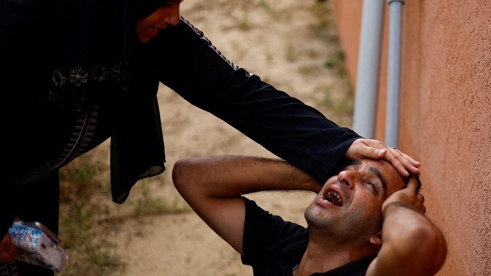 Mourners react at a hospital in Khan Younis, in the southern Gaza Strip (17 October 2023)