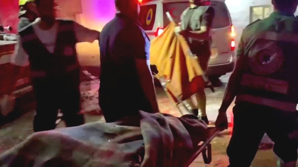 Izrael i Palestinci: U napadu na bolnicu u Gazi nastradale stotine, kažu zdravstveni zvaničnici 1 Rescue workers carry a victim of the explosion at Gaza City's Al-Ahli Arab hospital (17 October 2023)