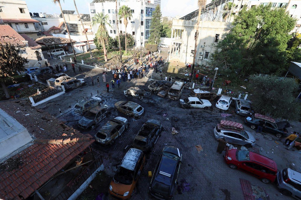 A view shows an area of Al-Ahli hospital following the blast. Burnt out cars can be seen in the foreground