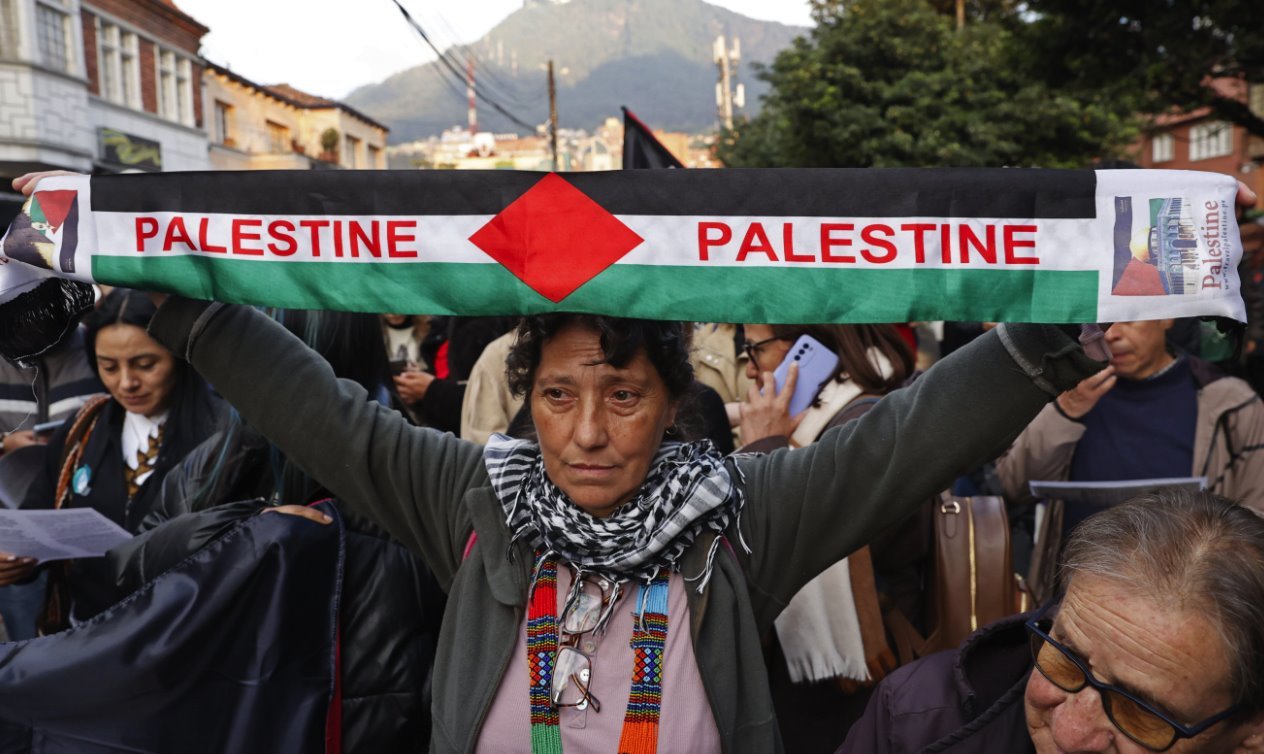 A woman holds a Palestine banner among protesters in Bogota, Colombia