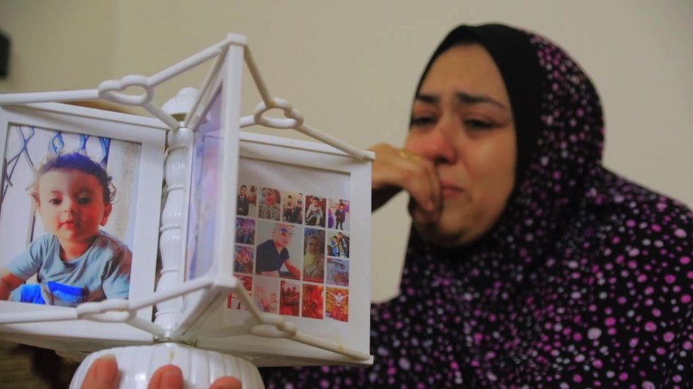 Nour is crying as she looks at pictures of her family