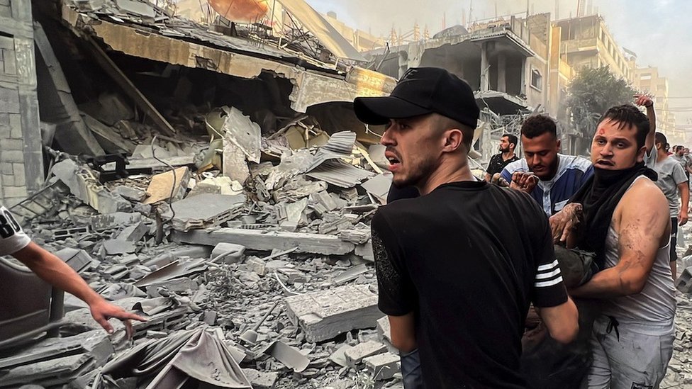 Izrael i Palestinci: Broj mrtvih u Gazi premašio 8.000, povraćene telefonske veze, Hamas nudi razmenu zarobljenika 1 Muškarci iznose ranjenog iz ruševina