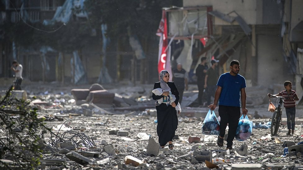 Ljudi prolaze razrušenim ulicama Gaze