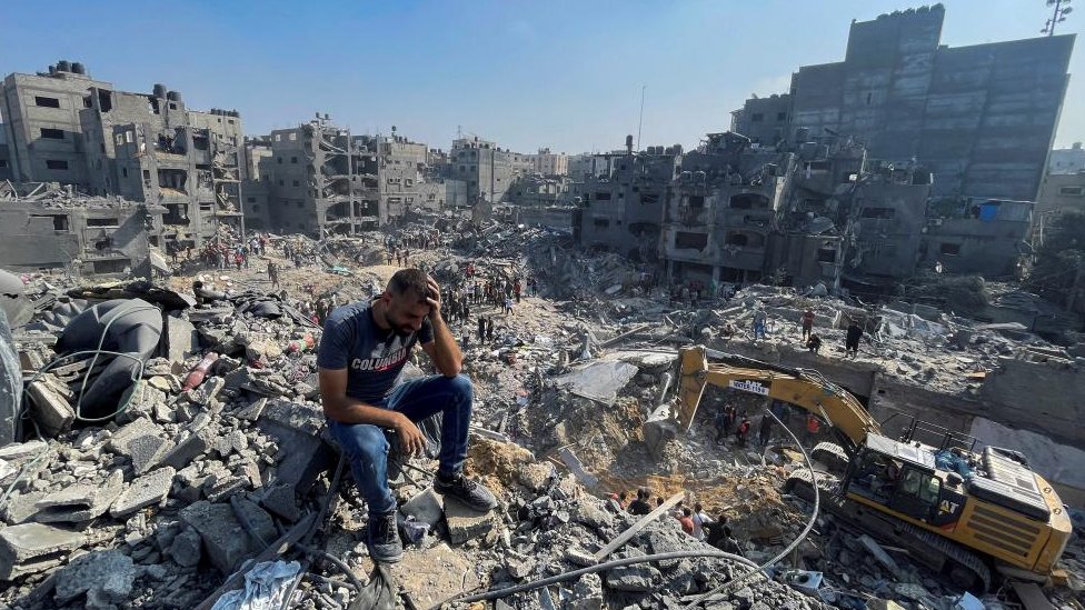 Izrael i Palestinci: Pet novih realnosti posle četiri nedelje rata 1 A man sits atop a pile of rubble following an Israeli strike on the Gaza Strip