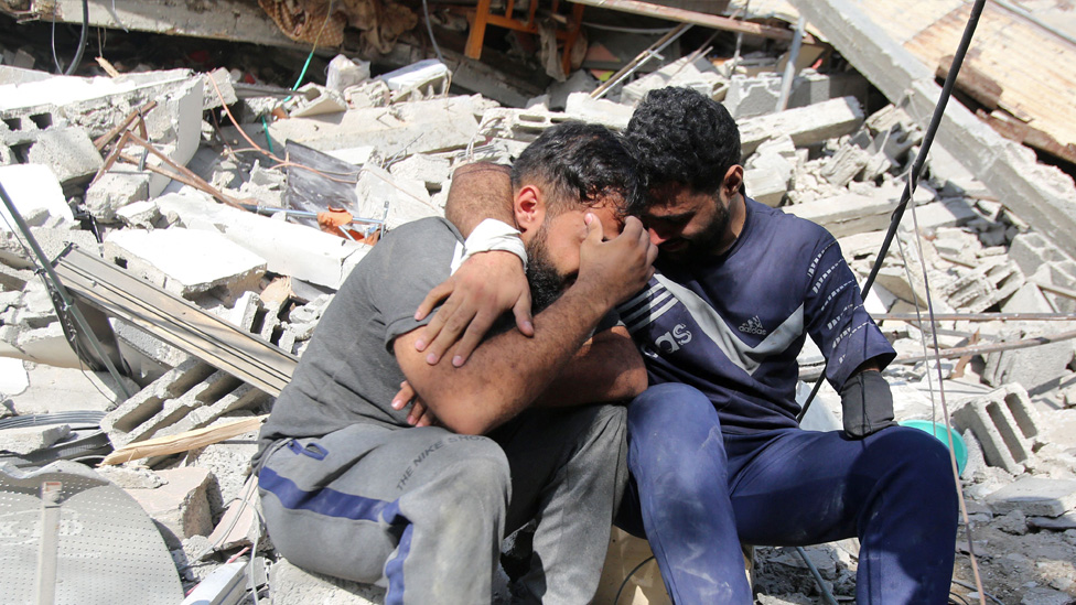 Izrael i Palestinci: Gaza postaje „groblje za decu", navode UN, izraelski šef diplomatije tvrdnju smatra sramnom 2 Palestinians mourn as they sit on the rubble of a building in Gaza City's Shati refugee camp on 6 November