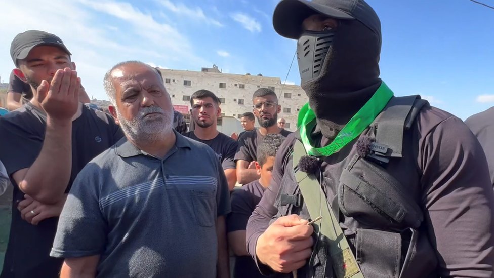 Borac Hamasa govori za BBC dok muškarci posmatraju
