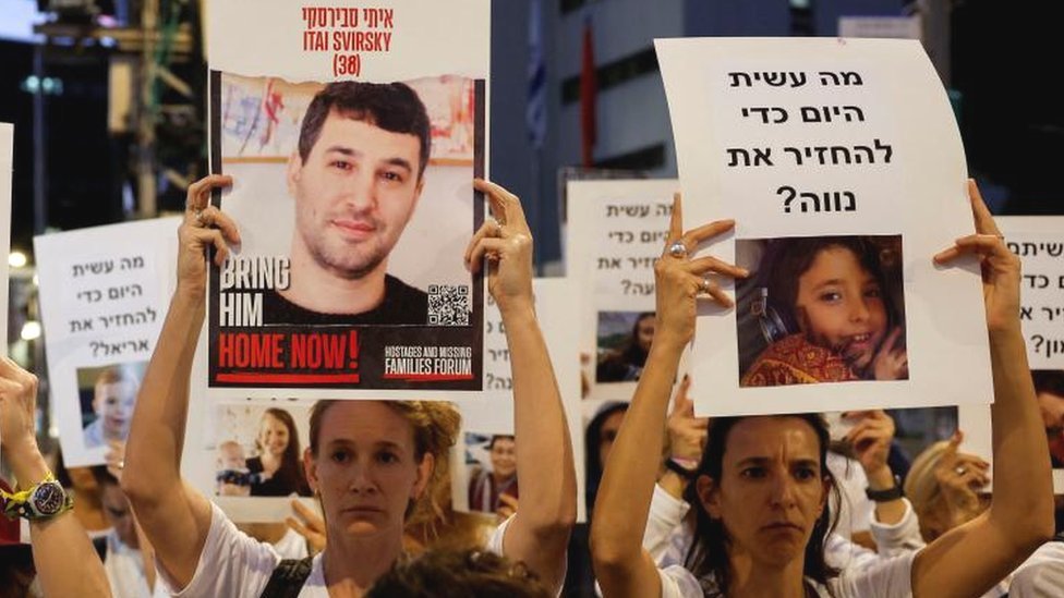 Protesters hold signs demanding the liberation of hostages who are being held in the Gaza Strip