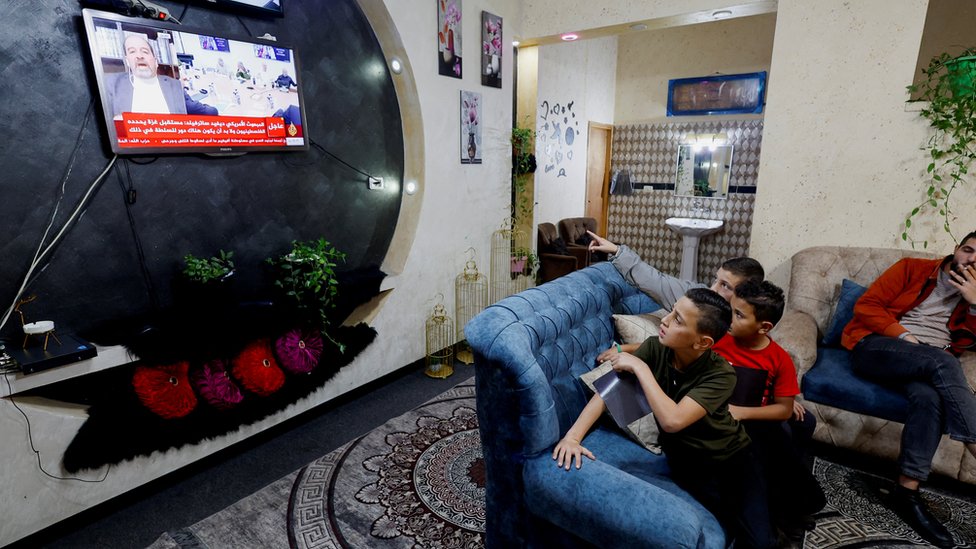 Porodica jednog od otetih Palestinaca prati televizijske vesti u domu u Hebronu, u okupiranoj Zapadnoj obali